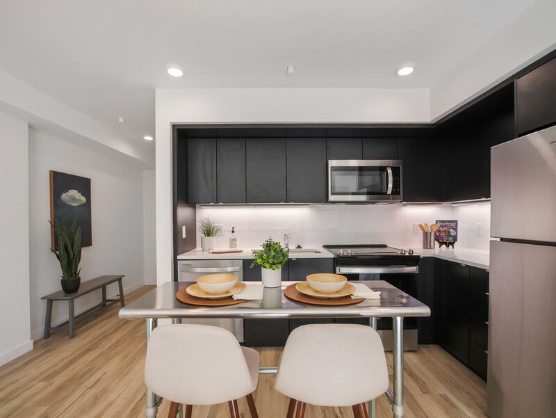 Kitchen with dark cabinets, quartz counters and stainless appliances